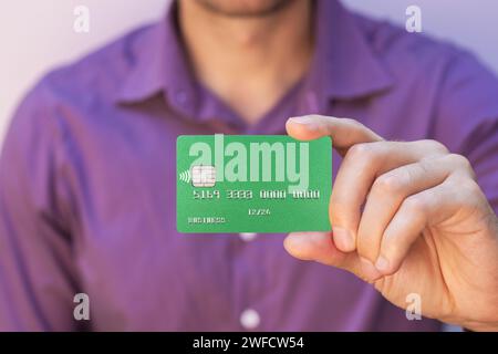 primo piano della carta di credito verde con custodia a mano Foto Stock