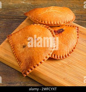 Due torte fatte in casa appoggiate su un tagliere di legno Foto Stock