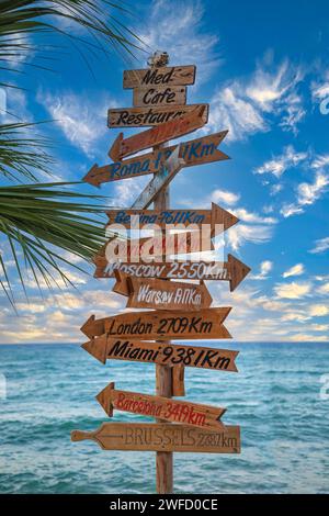 Hersonissos, Creta, Grecia - 23 luglio 2021: Cartelli turistici e ornamentali che segnano la direzione e la distanza dalle famose città del mondo. Foto Stock
