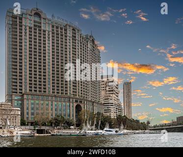 CAIRO, EGITTO - 26 APRILE 2022: Vista dal fiume Nilo con il Four Seasons Hotel Cairo a Nile Plaza, Water taxi Garden City Station di fronte e altro ancora Foto Stock