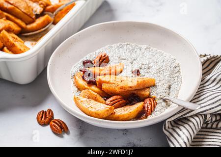 Budino di Chia con mele caramellate, cannella, noci pecan e mirtilli rossi. Ricetta invernale per la colazione vegana. Foto Stock