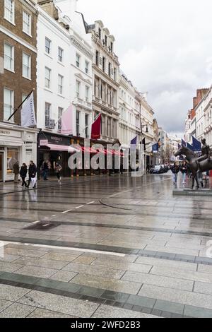 New Bond Street in un giorno di pioggia nel marzo 2023 a Londra. Ci sono statue a destra e splendidi edifici antichi a sinistra Foto Stock