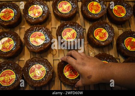 Bandung, Giava Occidentale, Indonesia. 30 gennaio 2024. I lavoratori preparano il tipico kue keranjang (torte da cesto) prima delle celebrazioni del capodanno cinese in una casa di produzione a Bandung. Le vendite di questa torta aumentano prima della celebrazione del Capodanno cinese. Questa torta, che viene fatta in diciotto ore, può produrre da 4.000 a 5.000 pezzi di torta al giorno. (Immagine di credito: © Dimas Rachmatsyah/ZUMA Press Wire) SOLO USO EDITORIALE! Non per USO commerciale! Foto Stock