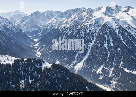 Vista panoramica dalla cima della pista sulle alte montagne innevate. Karakol Gorge, stazione sciistica in Kirghizistan. Paesaggio naturale invernale, catena montuosa Foto Stock