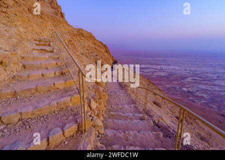 Masada, Israele - 19 gennaio 2024: Vista all'alba degli escursionisti che salgono alla fortezza di Masada attraverso il sentiero dei serpenti. Costa del Mar morto, deserto della Giudea, sud Foto Stock