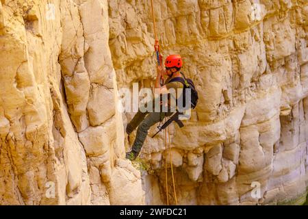 Masada, Israele - 19 gennaio 2024: Vista del paesaggio della valle desertica del Rahaf, con i visitatori che praticano la discesa in corda doppia. Costa del Mar morto, Judaean Deser Foto Stock