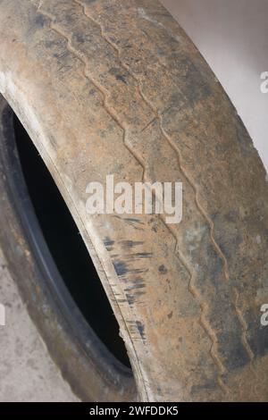 primo piano della superficie dei vecchi pneumatici usurati, degli pneumatici sporchi e usati presi in considerazione in modo selettivo, guida sicura e concetto di manutenzione del veicolo Foto Stock