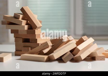 Un mucchio di blocchi di legno a torre su sfondo chiaro. Foto Stock