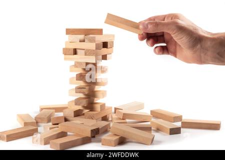 La torre da blocchi di legno e di mano d'uomo prendere un blocco. Foto Stock