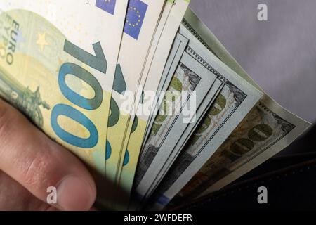 Contanti da 100 dollari e banconota da 100 euro, in portafoglio. Un sacco di banconote da cento dollari da vicino. dollari nel portafoglio. Foto Stock