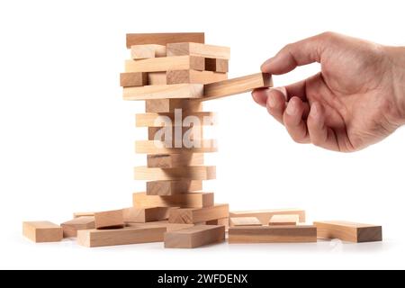 La torre da blocchi di legno e di mano d'uomo prendere un blocco. Foto Stock