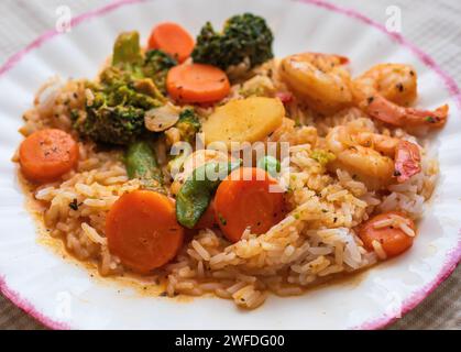Gamberi rossi al curry e verdure miste assortite su riso al gelsomino su un piatto di mirtilli bianchi; fatti in casa a Taylors Falls, Minnesota, USA. Foto Stock