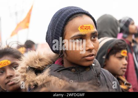 I bambini vengono dipinti con il nome di Lord Shri RAM indù sulla fronte, ad Ayodhya, Uttar Pradesh, India il 21 gennaio 2024. Foto Stock