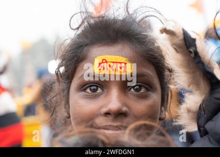 I bambini vengono dipinti con il nome di Lord Shri RAM indù sulla fronte, ad Ayodhya, Uttar Pradesh, India il 21 gennaio 2024. Foto Stock