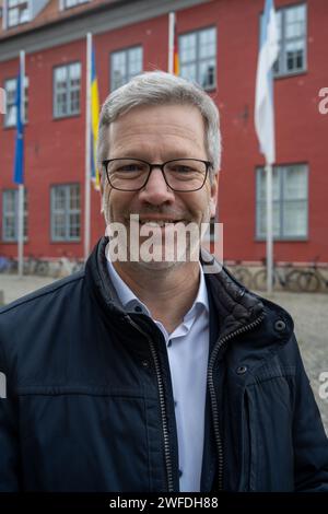 Greifswald, Germania. 30 gennaio 2024. Stefan Fassbinder (Alliance 90/The Green), sindaco di Greifswald, si trova di fronte al municipio. Ha vinto uno dei quattro titoli di "Sindaco Mondiale" per il 2023. Questo in riconoscimento del suo sostegno e della sua cooperazione con i comuni di Ucraina, Polonia e Brasile, la City Mayors Foundation ha annunciato lunedì sera a Londra. Ha anche offerto generoso aiuto ai rifugiati dall'Ucraina. (Al Lord Mayor di Greifswald onorato con il titolo di "sindaco mondiale") credito: Stefan Sauer/dpa/Alamy Live News Foto Stock