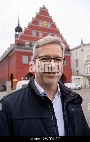 Greifswald, Germania. 30 gennaio 2024. Stefan Fassbinder (Alliance 90/The Green), sindaco di Greifswald, si trova di fronte al municipio. Ha vinto uno dei quattro titoli di "Sindaco Mondiale" per il 2023. Questo in riconoscimento del suo sostegno e della sua cooperazione con i comuni di Ucraina, Polonia e Brasile, la City Mayors Foundation ha annunciato lunedì sera a Londra. Ha anche offerto generoso aiuto ai rifugiati dall'Ucraina. (Al Lord Mayor di Greifswald onorato con il titolo di "sindaco mondiale") credito: Stefan Sauer/dpa/Alamy Live News Foto Stock