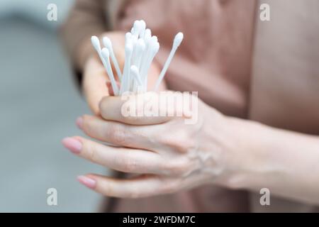 Bastoncini di cotone isolati in mano su sfondo bianco. Foto Stock