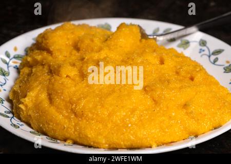 Polenta su piatto pronta da servire. Un tradizionale cibo di farina di mais. Foto Stock