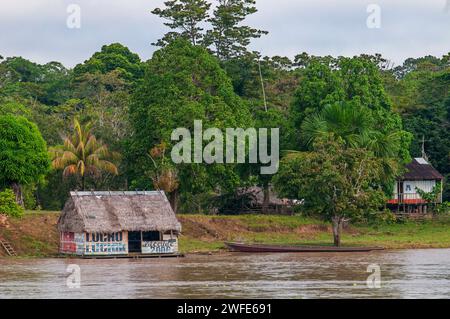 Case di legno nel villaggio dell'indiana vicino a Iquitos, Loreto, Perù, Sud America. Il dipartimento di Loreto, il più grande del Perù, era abitato da un anno Foto Stock