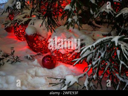 Decorazioni dell'albero di Natale nella neve sotto l'albero di Natale di notte Foto Stock