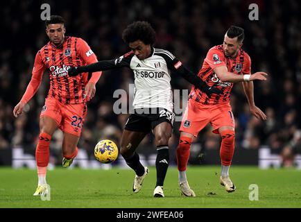 La Willian di Fulham si batte per il pallone con Ben Godfrey (a sinistra) e Jack Harrison (a destra) dell'Everton durante la partita di Premier League a Craven Cottage, Londra. Data immagine: Martedì 30 gennaio 2024. Foto Stock