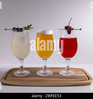 Cocktail e birra preparati e guarniti in studio sullo sfondo bianco Foto Stock