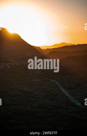 Un'immagine verticale di un luminoso cielo al tramonto sulle colline verdeggianti di o'ahu, Hawaii Foto Stock