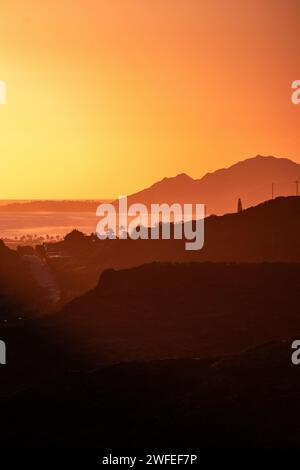 Un'immagine verticale di un luminoso cielo al tramonto sulle colline verdeggianti di o'ahu, Hawaii Foto Stock