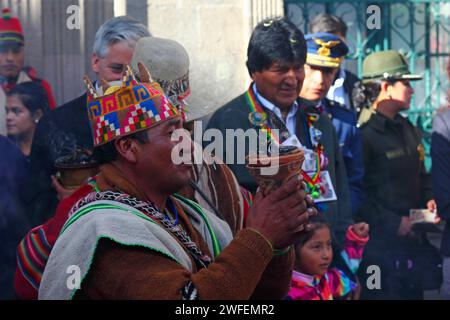La Paz, BOLIVIA; 24 gennaio 2015. Un Aymara amauta o sciamano che indossa un cappello di lana a quattro angoli esegue rituali con un bruciatore di incenso di fronte al presidente boliviano Evo Morales in un evento per celebrare l'inizio del festival Alasitas a la Paz. Dietro lo sciamano c'è il vice presidente Alvaro Garcia Linera. Foto Stock