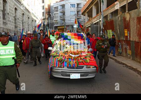 La Paz, BOLIVIA; 24 gennaio 2015. La polizia boliviana scorta un'antica illa (o statua) di un Ekeko (un dio Aymara dell'abbondanza) mentre viene sfilata sulla cima di un'auto decorata attraverso le strade di la Paz per celebrare la sua prima apparizione al festival Alasitas, che inizia oggi. La statua ha circa 2000 anni ed è stata realizzata dalla cultura Pucara. È stato portato dal sito archeologico di Tiwanaku in Svizzera nel 1858, e restituito in Bolivia dal Museo di storia di Berna nel novembre 2014. Foto Stock