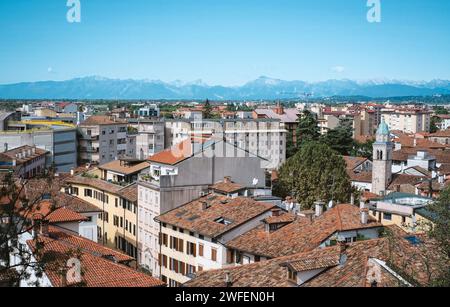 Una vista panoramica su Udine, città italiana con molti edifici e montagne sullo sfondo Foto Stock