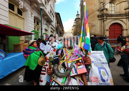 La Paz, BOLIVIA; 24 gennaio 2015. Un uomo vestito da ekeko partecipa a una sfilata per le strade di la Paz per accogliere il ritorno di un'antica illa (o statua) di un ekeko per la sua prima apparizione al festival Alasitas, che inizia oggi. L'ekeko è un dio Aymara dell'abbondanza e un personaggio particolarmente associato al festival. Sulla destra si trova una parte della chiesa di San Francisco. Foto Stock