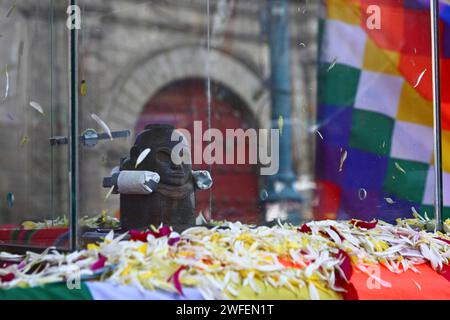 La Paz, BOLIVIA; 24 gennaio 2015. Un'antica illa (o statua) di un Ekeko (un dio Aymara dell'abbondanza) vista di fronte alla chiesa di san Francisco e una bandiera del wiphala mentre viene sfilata per le strade di la Paz per celebrare la sua prima apparizione al festival Alasitas, che inizia oggi. La statua ha circa 2000 anni ed è stata realizzata dalla cultura Pucara. È stato portato dal sito archeologico di Tiwanaku in Svizzera nel 1858, e restituito in Bolivia dal Museo di storia di Berna nel novembre 2014. Foto Stock