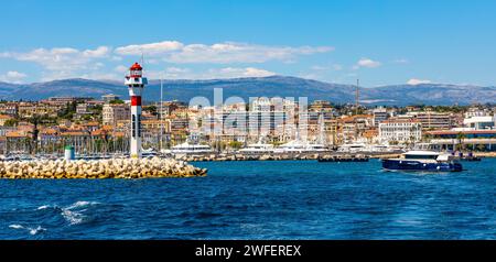 Cannes, Francia - 31 luglio 2022: Panorama sul mare di Cannes con faro sul frangiflutti e porto per yacht sulla Costa Azzurra del Mediterraneo Foto Stock
