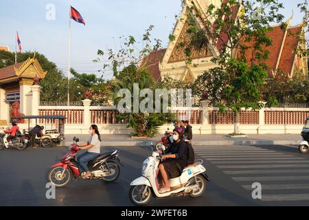 Le donne guidano scooter fuori dalla corte suprema della Cambogia a Phnom Penh Foto Stock