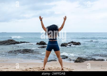 Fitness Woman, atleta, che fa salti sulla sabbia della spiaggia. Stile di vita sano. Foto Stock