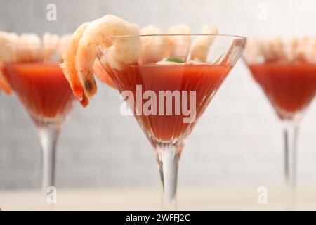 Gustoso cocktail di gamberi con salsa nei bicchieri sul tavolo, primo piano Foto Stock