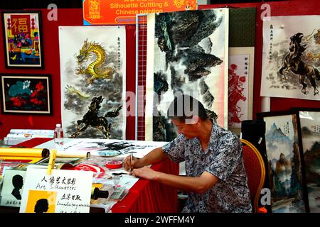 Singapore, 26 gennaio 2024. Chinatown, un artista cinese al lavoro al mercato, in grado di dipingere un quadro sul posto. Foto Stock