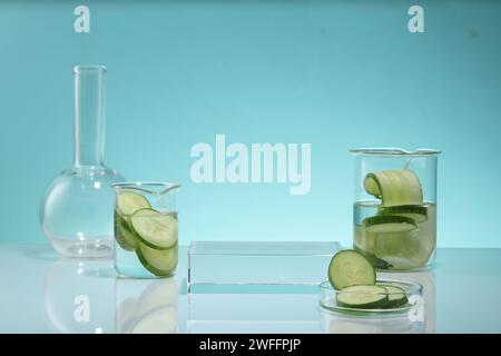 Fette di cetriolo contenute in una piastra di Petri in vetro e in becher. Un podio rettangolare con spazio vuoto per la promozione del prodotto. Cetriolo (Cucumis sativus) extra Foto Stock