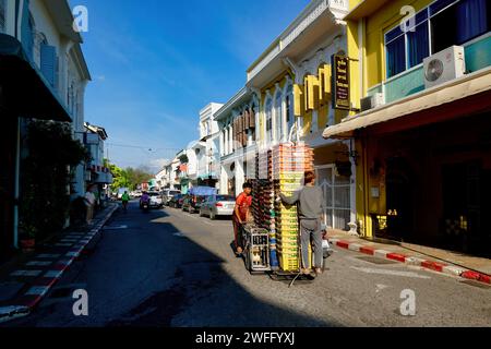 Le colorate botteghe in stile sino-portoghese nella città vecchia sono Phuket Town, Thailandia, una motocicletta con sidecar impilato in alto con casse che passano Foto Stock