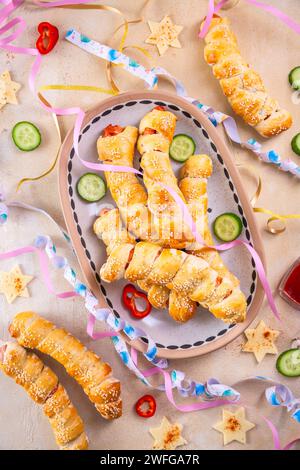 Maiale in coperta, salsicce lunghe avvolte in pasta lievitata - tradizionale carnevale, fasciing e cibo da festa Foto Stock