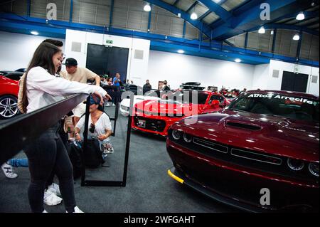 Bogotà, Colombia. 27 gennaio 2024. Un gruppo di persone si riunisce per guardare le muscle car durante l'MCM Show 2024 a Bogotà, Colombia, dove appassionati e collezionisti di automobili si riuniscono per apprezzare la cultura automobilistica colombiana intorno a tuning, supercar e classici, il 27 gennaio 2024. Foto di: Chepa Beltran/Long Visual Press Credit: Long Visual Press/Alamy Live News Foto Stock