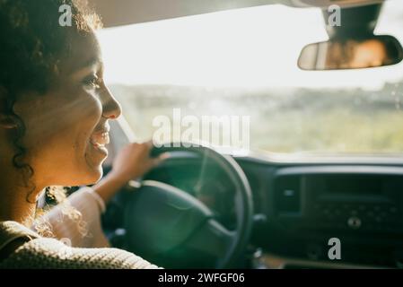 Felice giovane donna alla guida di auto Foto Stock