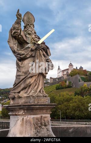 Statua di San Kilian sul vecchio ponte principale con la fortezza di Marienberg sullo sfondo Foto Stock