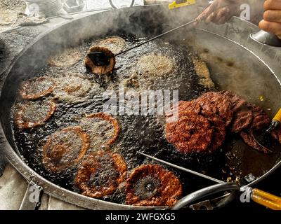 Il Chapli kebab è un popolare cibo di strada in Pakistan. Preparazione del chapli kabab presso un ristorante di cucina locale Foto Stock