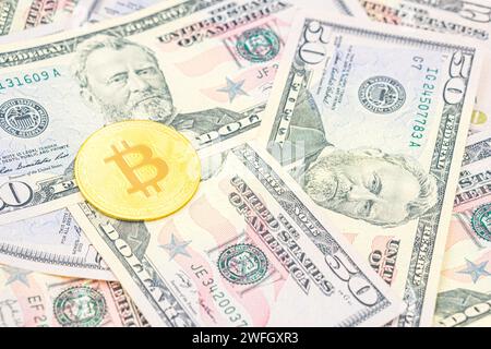 Bitcoin cash BTC, criptovaluta raffigurata come oro, moneta d'oro che giace sopra i dollari, denaro americano reale, 50 dollari, banconota da 50 dollari degli Stati Uniti. Bitcoin Foto Stock