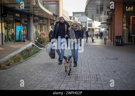 Novara, Italia, 16 gennaio 2024: Coppia con un cane che passeggia lungo il centro commerciale "Vicolungo The Style Outlets" Foto Stock