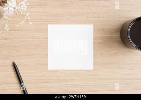 Mockup quadrato con una gypsophila e accessori da lavoro sul tavolo in legno. Foto Stock