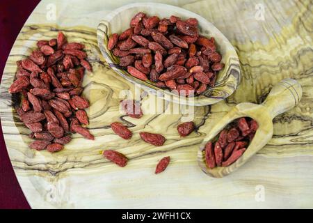 wolfberry cinese, vite matrimoniale, vite matrimoniale barbary, medlar rosso, albero da tè del Duca di Argyll (Lycium barbarum), bacche di goji essiccate sul tavolo Foto Stock