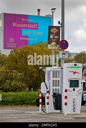 Stazione di ricarica e grande poster per acciaio climatico presso lo stabilimento ThyssenKrupp Steel Europe, Germania, Renania settentrionale-Vestfalia, Ruhr area, Bochum Foto Stock